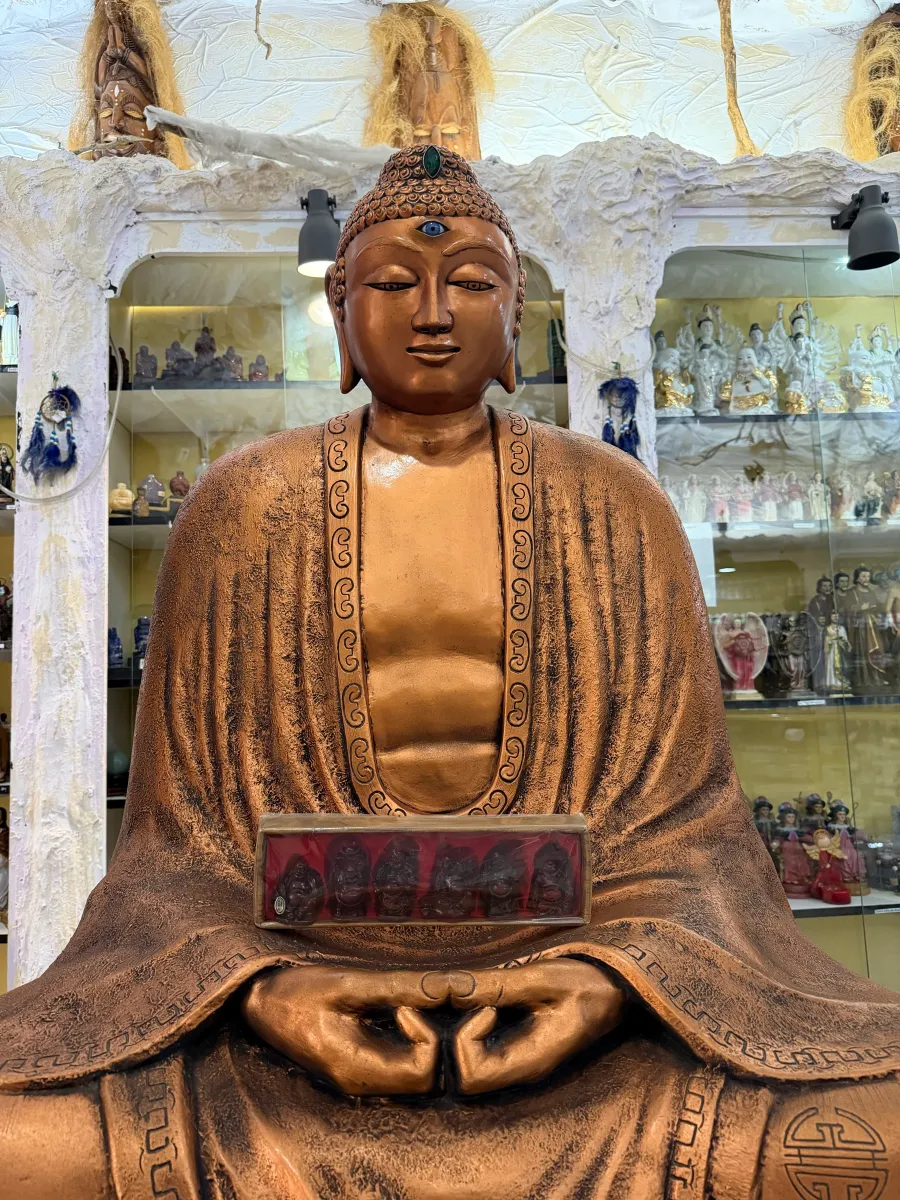 Buda sentado entre las vitrinas de la tienda