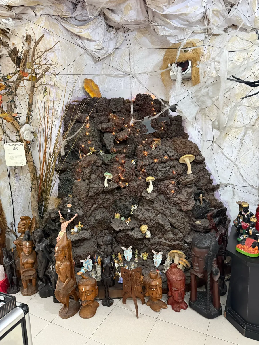 Rincón de roca volcánica con setas y tallas de madera en Bazar Kalunga